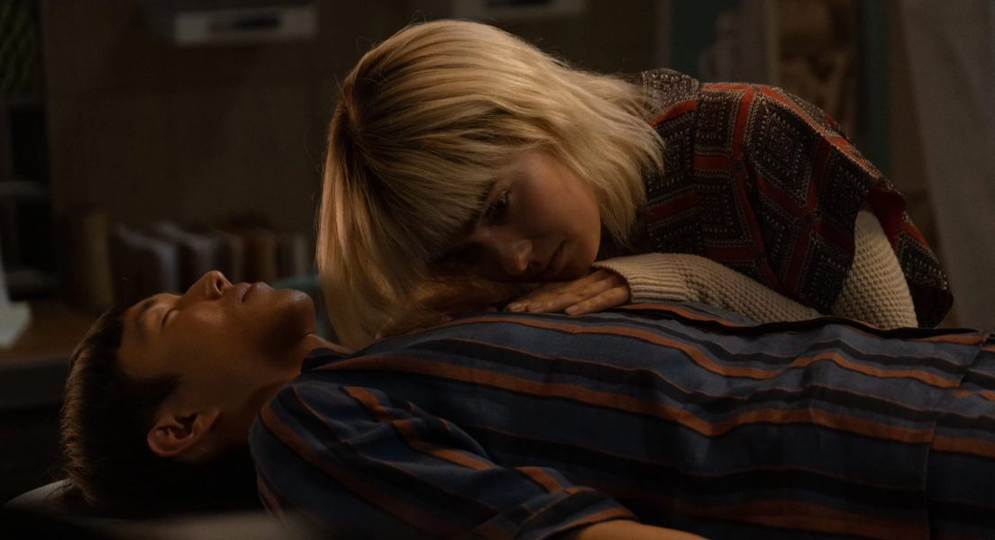 Yang est alongé et Ada est penchée au dessus de sa poitrine, une main sur celle-ci.