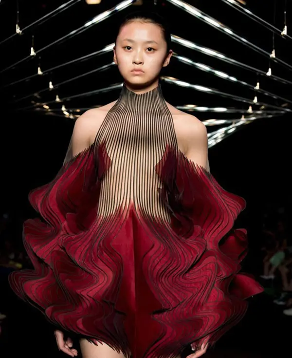 femme avec courte robe futurite: gros volume dans le bas, plisée, noir et rouge