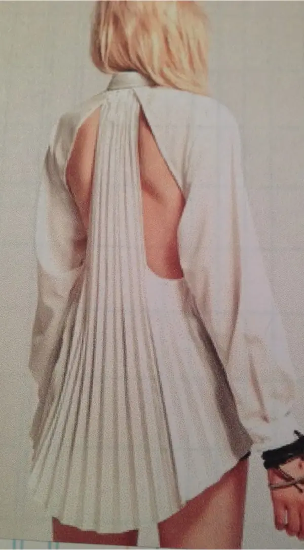 femme avec courte robe blanche plisée et découpes dans le dos