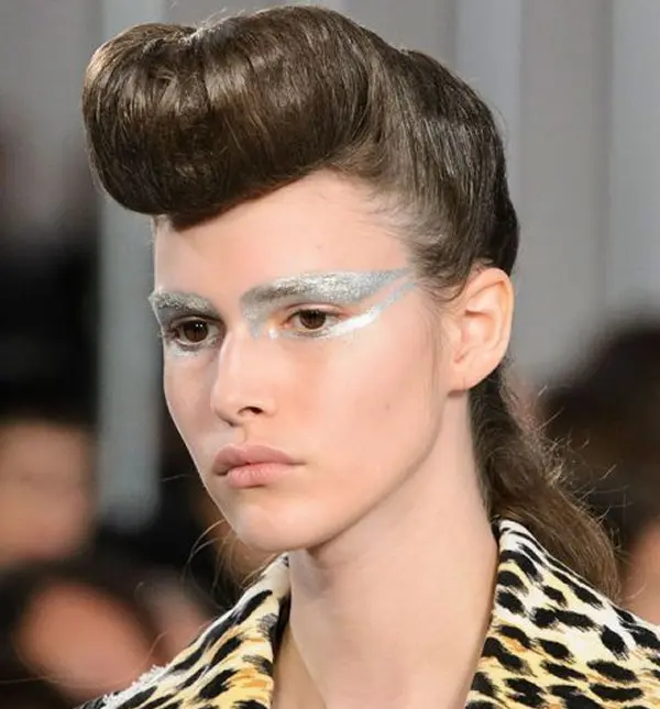 femme avec un makeup métalique chargé au niveau des yeux et coiffure imposante