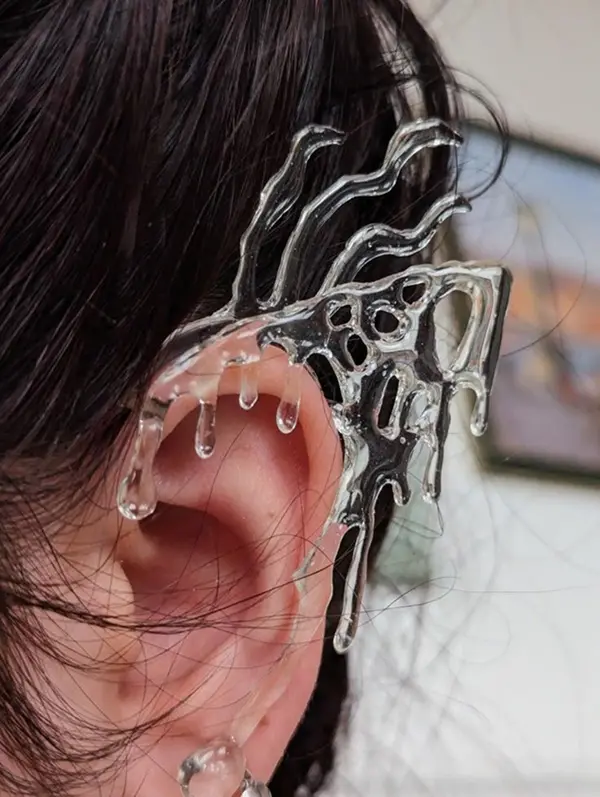 oreille avec un bijou immposant transparent sur le haut de l'oreille