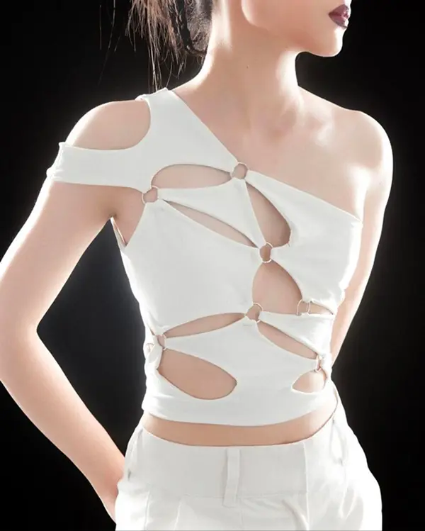 femme avec haut blanc asymétrique et découpes