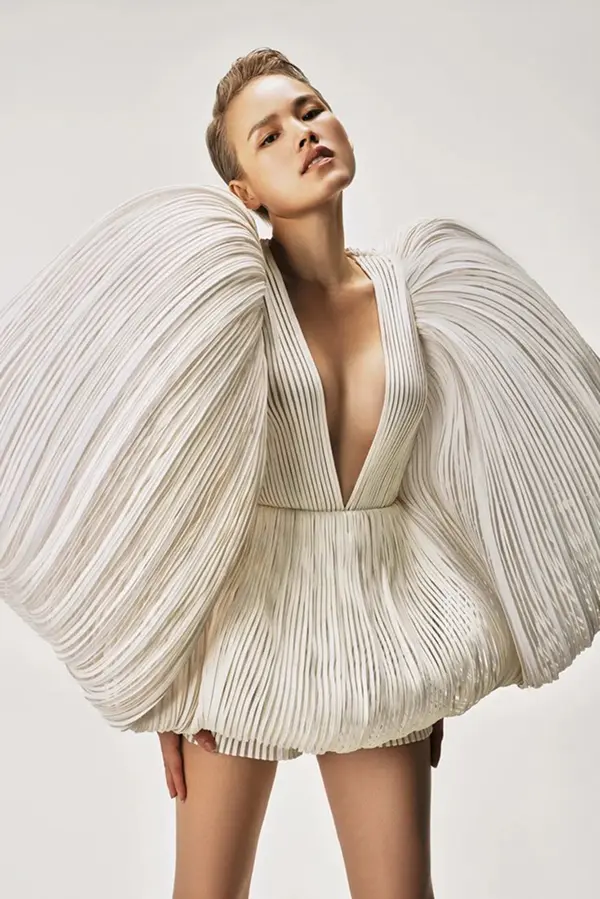 femme avec courte robe blanche volumineuse et plissée